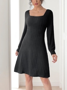 Gros plan sur la maille texturée et l'encolure carrée de cette robe trapèze noire