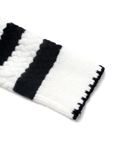 Close-up of black and white striped knit cardigan with detailed cable knit pattern