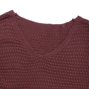 Close-up of a V-neck hollow-out knitted dress in reddish-brown with elegant textures