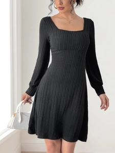 Détail d'une robe en maille noire avec une encolure carrée élégante et une coupe ajustée