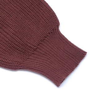 Close-up of ribbed cuffs and waffle knit texture on deep red long-sleeved dress