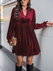 Détail d'une robe en velours bordeaux à manches longues avec col en V et texture plissée
