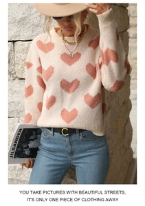 Detailed view of pink heart jacquard patterns on long-sleeve knit sweater fabric
