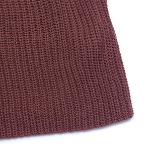 Macro shot of burgundy knit fabric texture showing thick ribbed waffle knit details