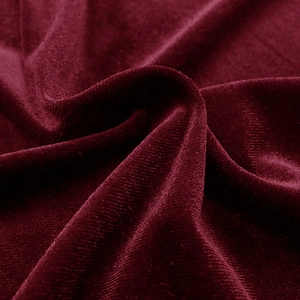 Macro shot of premium wine red velvet fabric showing soft texture and silky luster