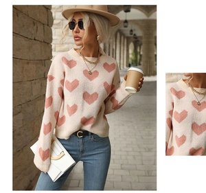 Close-up of pink heart jacquard pattern on a cream crewneck long-sleeved sweater