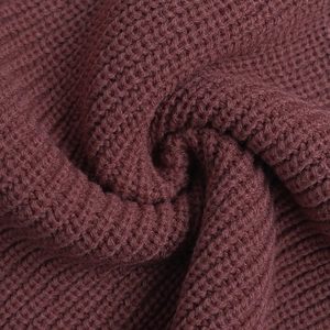 Detailed macro shot of thick dark red ribbed knit fabric showing soft weave texture