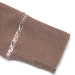 Detailaufnahme von braunem Rippstrickgewebe mit weißen Overlock-Nähten im Fokus