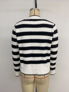 Detail of black and white striped knit sweater showing 3D textured ripple wave pattern
