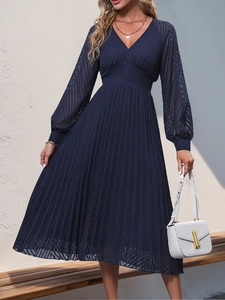 Detail of navy blue pleated maxi dress with V-neckline and elegant lantern sleeves
