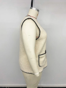 Dettaglio del gilet sherpa crema con cuciture a contrasto nere e tasca laterale
