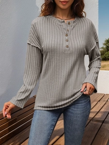 Detailaufnahme des grauen Langarmshirts mit Knopf-Henley-Ausschnitt und Rippenmuster
