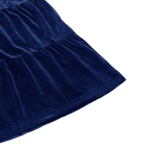 Detailed close-up of blue velvet tiered dress hem with precision stitching and soft sheen