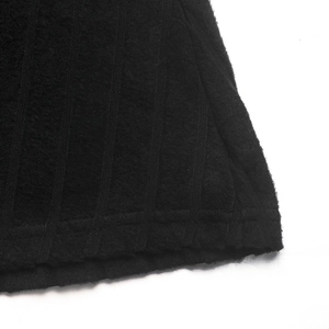 Détail de la robe trapèze en tricot noir montrant la texture côtelée et la finition de l'ourlet