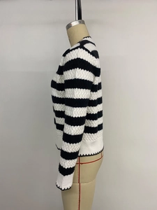 Close-up of the black and white striped knit texture and ribbed cuffs on the sweater