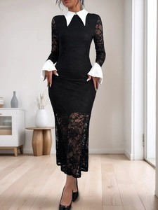Détail d'une robe en dentelle noire avec col contrasté blanc et manches cloche