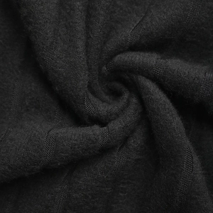 Détail macro du tissu en maille noire avec motifs nervurés et texture de fibre premium