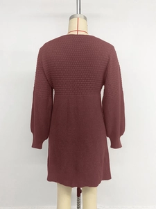 Detail of burgundy knit dress showing textured checkered patterns and ribbed cuffs