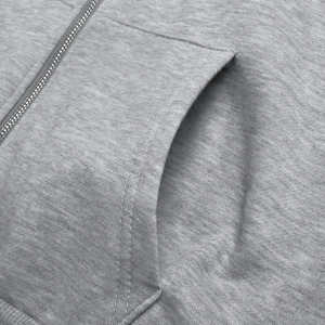 Detail of light gray hoodie showing metallic zipper, side pocket and ribbed knit texture