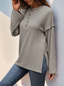 Detail eines grauen Langarmshirts mit Rippenmuster, Henley-Ausschnitt und Seitenschlitz