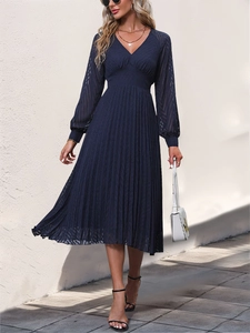 Detail view of navy blue V-neck pleated midi dress with lace textures and sheer long sleeves