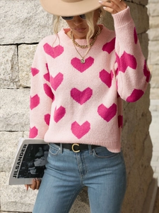 Detail of pink knitted sweater with dark pink heart jacquard patterns and crew neck