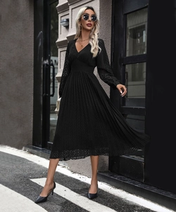 Detail of elegant black pleated V-neck midi dress with long lantern sleeves in urban style