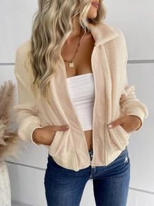 Détail d'une veste en polaire blanc cassé avec fermeture éclair et poignets côtelés