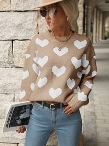 Close-up of khaki knit sweater with white heart pattern and ribbed crew neck texture