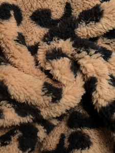 Gros plan sur la fourrure synthétique léopard et la texture moelleuse de ce manteau femme