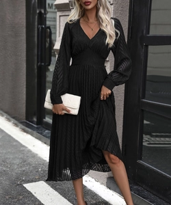 Detail of elegant black V-neck maxi dress featuring textured fabric and pleated skirt