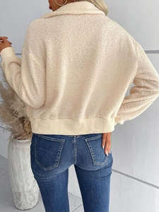 Vue détaillée de la veste en polaire sherpa beige avec poignets côtelés et peluche