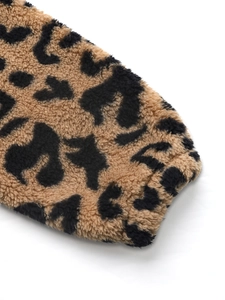 Gros plan d'une manche de veste en laine léopard montrant la texture douce et le poignet