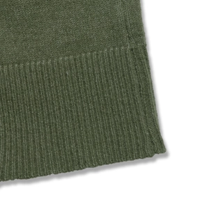 Gros plan sur un tricot côtelé vert armée montrant la texture épaisse et les coutures
