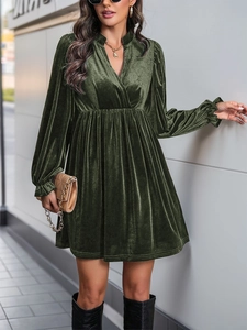 Dettaglio vestito corto in velluto verde scuro con scollo a V e vita elastica