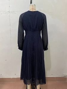 Back view of a long-sleeved pleated maxi dress with high waist and invisible zipper detail