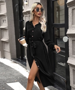 Detail of a black long-sleeve shirt dress with pink buttons and a side slit design