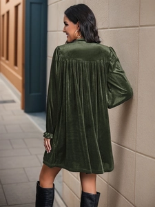 Vista posteriore dettagliata dell'abito in velluto verde scuro con eleganti polsini a balze