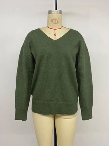 Détail du pull en tricot vert foncé à col en V avec poignets côtelés et texture douce