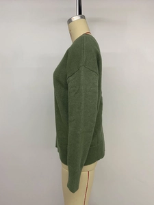 Détail du pull en maille vert foncé avec poignets côtelés et texture en laine