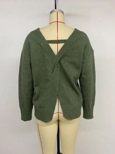 Détail du pull en maille vert foncé avec nœud croisé et décolleté plongeant dans le dos
