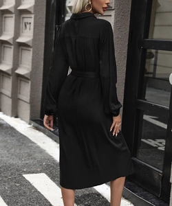 Detailed back view of a black long-sleeved shirt dress featuring a cinched waist and belt