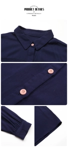 Detail view of navy blue shirt dress with contrast pink buttons and twill texture