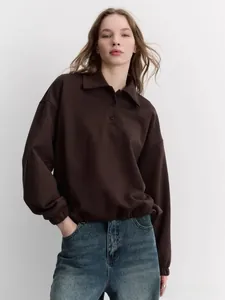 Close-up of polo collar sweatshirt with button details and elastic hem in dark brown