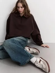 Detail of dark brown long sleeve polo sweatshirt with a relaxed drop shoulder fit