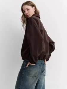 Detail of coffee brown sweatshirt with ribbed cuffs and hem paired with casual jeans