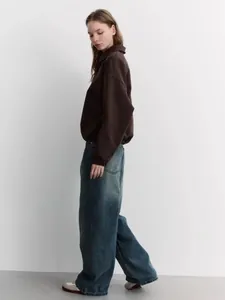 Detail of loose-fit brown lapel sweatshirt and washed blue wide-leg jeans outfit
