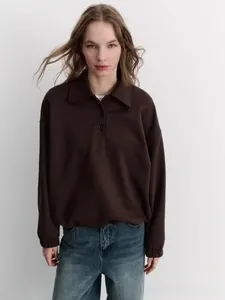 Detail of the brown polo collar sweatshirt fabric and buttoned neckline closure