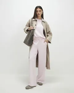 Detail of pink loungewear set with khaki trench coat and grey tote bag