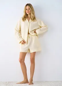 Close-up of light yellow waffle knit texture on breathable cotton shirt and shorts set